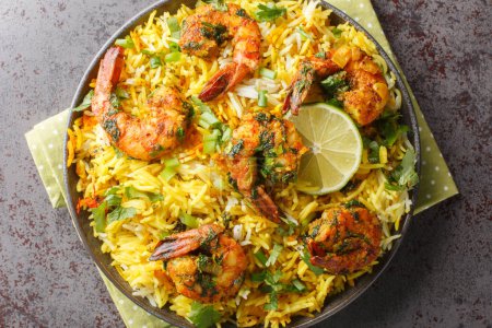 Photo for Asian saffron pilaf with shrimp and lots of herbs such as dill, green onions, cilantro close-up on a plate on the table. Horizontal top view from abov - Royalty Free Image