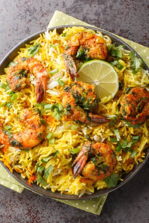 Photo for Persian style shrimp rice with lots of herbs and spices closeup on the plate on the table. Vertical top view from abov - Royalty Free Image