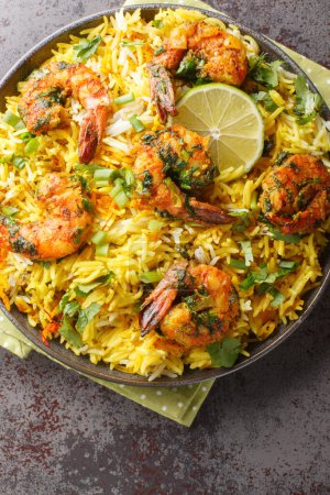 Photo for Fragrant seafood pilaf with shrimp and a lot of herbs such as dill, green onions, cilantro close-up on a plate on the table. Vertical top view from abov - Royalty Free Image