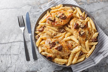 Photo for Creamy Marry Me Chicken pasta with sun-dried tomatoes, cheese, herbs and aromatic sauce close-up in a plate on a marble table. Horizontal top view from abov - Royalty Free Image
