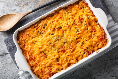 King Ranch Chicken Casserole is a Southern Texas staple dish close-up in a baking dish on a marble table. Horizontal top view from abov