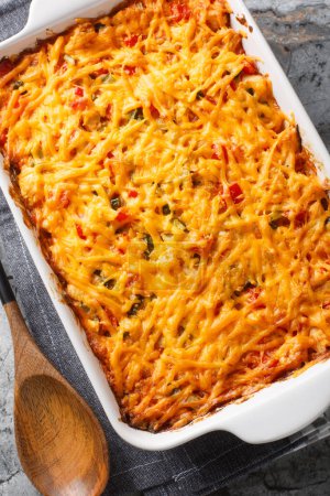 Photo for King Ranch chicken casserole is a tender chicken, creamy sauce, tortilla chips and plenty of cheese close-up in a baking dish on a marble table. Vertical top view from abov - Royalty Free Image