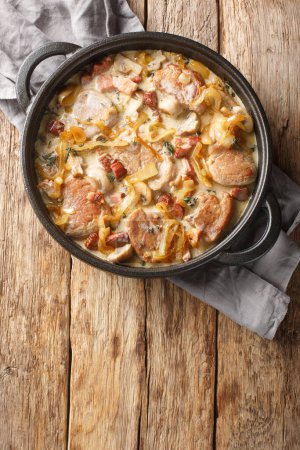 Photo for Morbradboffer i flodesovs pork tenderloin with onions, bacon and mushrooms in a creamy sauce closeup on the pan on the table. Vertical top view from abov - Royalty Free Image