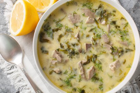 Magiritsa is a Greek soup made from lamb offal, associated with the Easter tradition close-up in a bowl on a marble table. Horizontal top view from abov