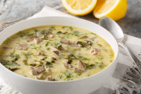 Magiritsa is a Greek soup made from lamb offal, associated with the Easter tradition close-up in a bowl on a marble table. Horizonta