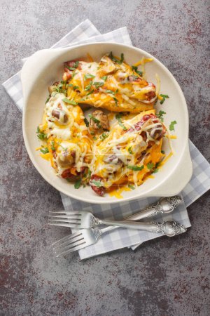 Alice Springs Chicken es un delicioso queso, tocino y champiñones, delicioso primer plano desorden caliente en el plato para hornear en la mesa. Vista superior vertical desde arriba