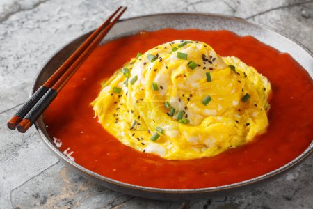 Tornade d'omelette tourbillonnante asiatique avec riz frit et sauce piquante en gros plan dans une assiette sur la table. Horizonta