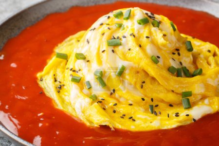 Tornade d'omelette tourbillonnante coréenne sur le riz frit et sauce piquante en gros plan dans une assiette sur la table. Horizonta