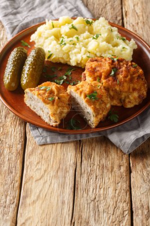 Holandsky rizek Czech Dutch or Holland Schnitzel is a breaded and fried ground pork schnitzel with grated cheese served with mashed potatoes closeup on the plate on the table. Vertica
