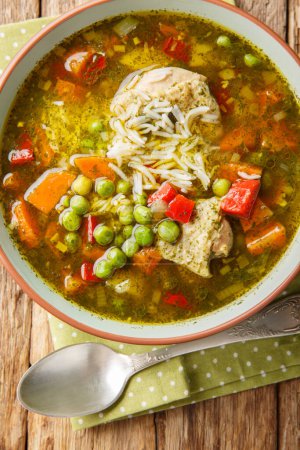 Foto de Sopa de pollo cilantro con arroz y verduras de cerca en un tazón sobre la mesa. Vista superior vertical desde arriba - Imagen libre de derechos