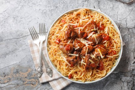 Carne estofada en una salsa de tomate de vino picante servida con espaguetis de cerca en un plato sobre la mesa. Vista superior horizontal desde arriba