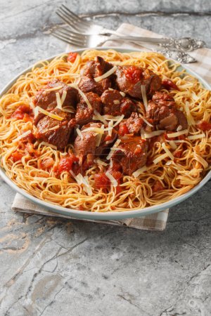 Kokkinisto griego estofado carne de vacuno en salsa roja con espaguetis pasta primer plano en el plato sobre la mesa. Vertica