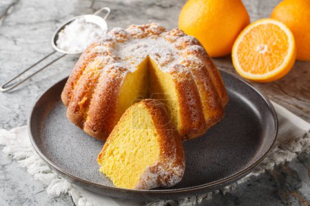 Meskouta is a simple, soft, fluffy orange cake close-up on a plate on the table. Horizonta