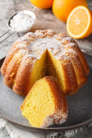 Traditional vanilla pound cake with orange juice and zest close-up on a plate on the table. Vertica