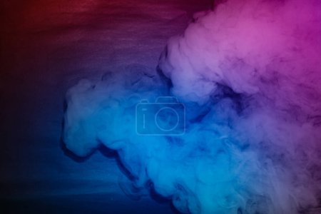 Téléchargez les photos : Fumée colorée sur fond noir avec espace de copie - en image libre de droit