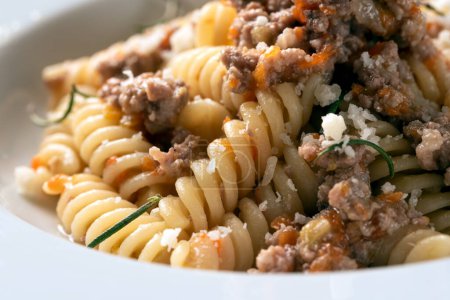 Téléchargez les photos : Assiette de délicieux fusilli garnie de sauce ragu de bœuf blanc, cuisine italienne - en image libre de droit