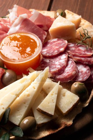 Foto de Bandeja con deliciosas comidas italianas, jamón, salami, guanciale, pecorino y parmesano - Imagen libre de derechos