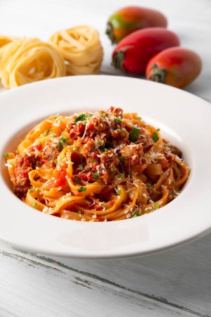 Foto de Pasta italiana servida en plato y tomates - Imagen libre de derechos