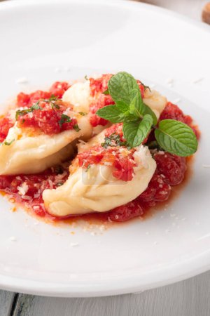 Photo for Culurgiones, typical sardinian ravioli filled with potato and pecorino cheese with tomato sauce - Royalty Free Image