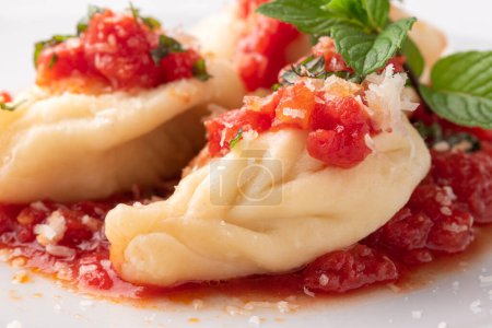 Téléchargez les photos : Culurgiones, raviolis sardiniens typiques remplis de pommes de terre et fromage pecorino à la sauce tomate - en image libre de droit