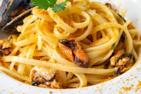 Foto de Plato de deliciosos espaguetis con mejillones, almejas y bottarga, comida italiana - Imagen libre de derechos