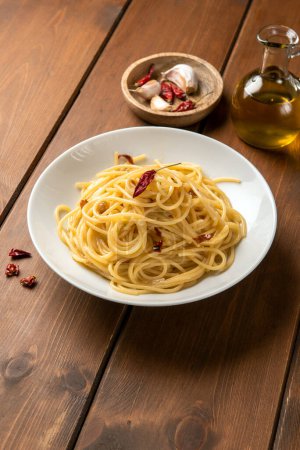 Foto de Placa de deliciosos espaguetis típicos con aceite de oliva, ajo y chile, pasta italiana - Imagen libre de derechos