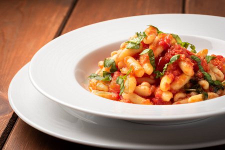Foto de Plato de deliciosos cavatelli con salsa de tomate, una receta tradicional del sur de Italia de pasta - Imagen libre de derechos