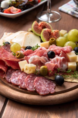 Foto de Bandeja de deliciosos alimentos italianos - prosciutto crudo, queso, nueces e higos frescos - Imagen libre de derechos