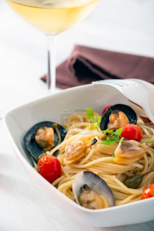 Foto de Plato de deliciosos espaguetis con almejas, mejillones y bottarga, cocina italiana - Imagen libre de derechos