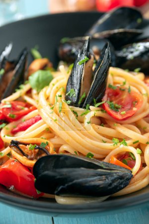 Foto de Placa de deliciosos espaguetis con mejillón y salsa de tomate cherry, comida italiana - Imagen libre de derechos