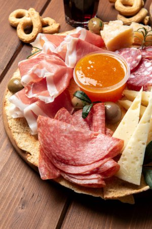 Foto de Bandeja con varios aperitivos italianos: salami, pecorino, jamón, parmesano y mostaza, comida europea - Imagen libre de derechos