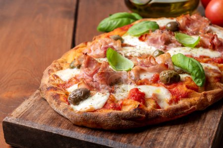 Téléchargez les photos : Délicieuse pinsa romaine à la mozzarella, sauce tomate, olives et prosciutto, cuisine italienne - en image libre de droit