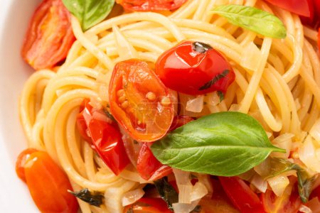 Téléchargez les photos : Assiette de délicieux spaghettis au basilic, tomate et fromage, cuisine italienne - en image libre de droit