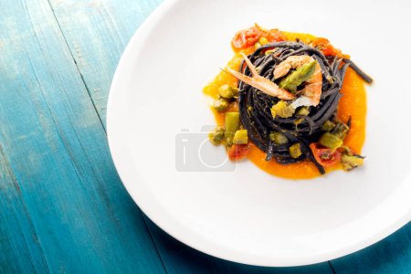 Foto de Plato de deliciosa tinta de calamar linguine con scampi y espárragos, cocina italiana - Imagen libre de derechos