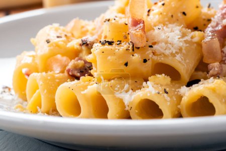 Photo for Plate of traditional pasta alla carbonara, a typical roman recipe of maccheroni with guanciale, egg sauce, pecorino and black pepper, italian food - Royalty Free Image