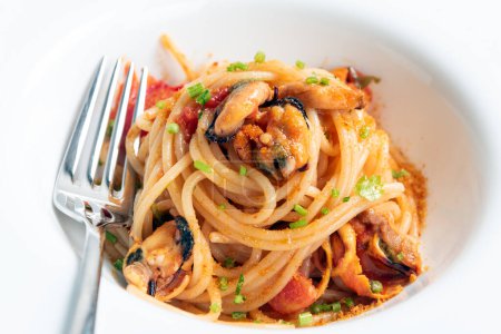 Foto de Placa de deliciosos espaguetis gourmet con mejillón, tomates y bottarga, cocina italiana - Imagen libre de derechos