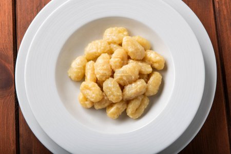 Téléchargez les photos : Plat de délicieux gnocchi aux pommes de terre avec beurre et fromage sur table en bois, cuisine italienne - en image libre de droit