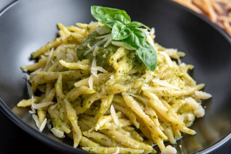Delicious trofie with pesto alla genovese, typical Italian pasta, Mediterranean food