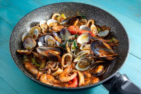 Foto de Sartén con deliciosa sopa de mariscos, comida italiana, cocina mediterránea - Imagen libre de derechos