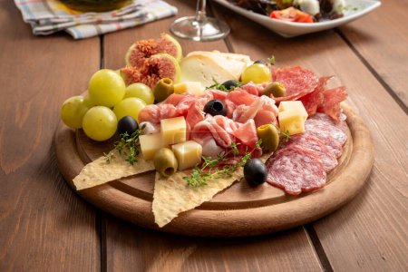 Photo for Closeup of delicious cheeses, salami and fresh fruit, italian gastronomy, european food - Royalty Free Image