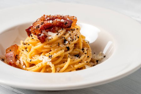 Téléchargez les photos : Délicieux spaghetti alla carbonara, une recette romaine traditionnelle de pâtes garnie d'oeuf, pecorino et sauce au poivre noir, nourriture italienne - en image libre de droit