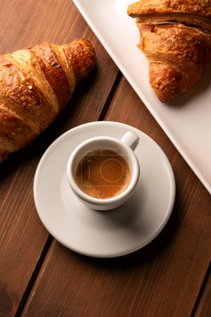 Foto de Una taza de espresso italiano con cornetto fresco, desayuno europeo - Imagen libre de derechos