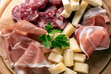 Foto de Bandeja con deliciosos aperitivos italianos: jamón, gorgonzola, salami y pecorino - Comida europea - Imagen libre de derechos