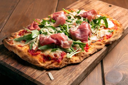 Photo for Close-up shot of delicious pizza on wooden board - Royalty Free Image