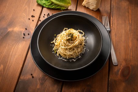 Photo for Close-up shot of delicious pasta with parmesan cheese in black bowl - Royalty Free Image