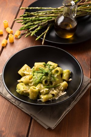 close-up shot of delicious pasta with asparagus on wooden tabletop