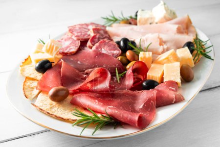 Foto de Placa de deliciosos aperitivos europeos - salami, pecorino picante, pavo, guanciale, queso - Imagen libre de derechos