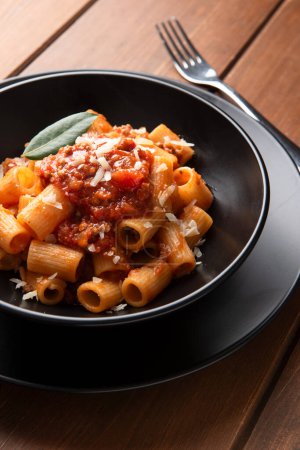 Photo for Dish of delicious rigatoni with meat sauce and mediterranean herbs, Italian cuisine - Royalty Free Image