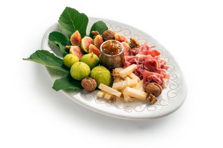 Foto de Bandeja con deliciosos alimentos italianos. jamón fresco, pecorino, mermelada e higos frescos - Imagen libre de derechos