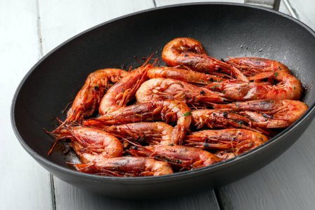 Téléchargez les photos : Délicieuses crevettes cuites dans une casserole à l'ail, au persil et à l'huile, nourriture méditerranéenne - en image libre de droit